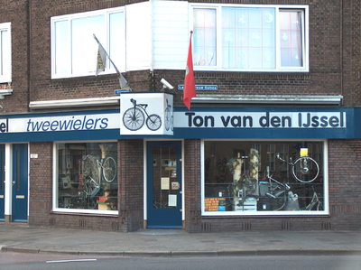 819622 Gezicht op de winkelpui van Ton van den IJssel - Tweewielers (Groeneweg 107) te Utrecht; rechts de Laan van ...